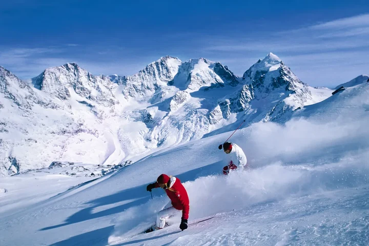 Zwei Skifahrer im Tiefschnee vor einem Gletscherpanorama – Skifahren abseits der Piste
