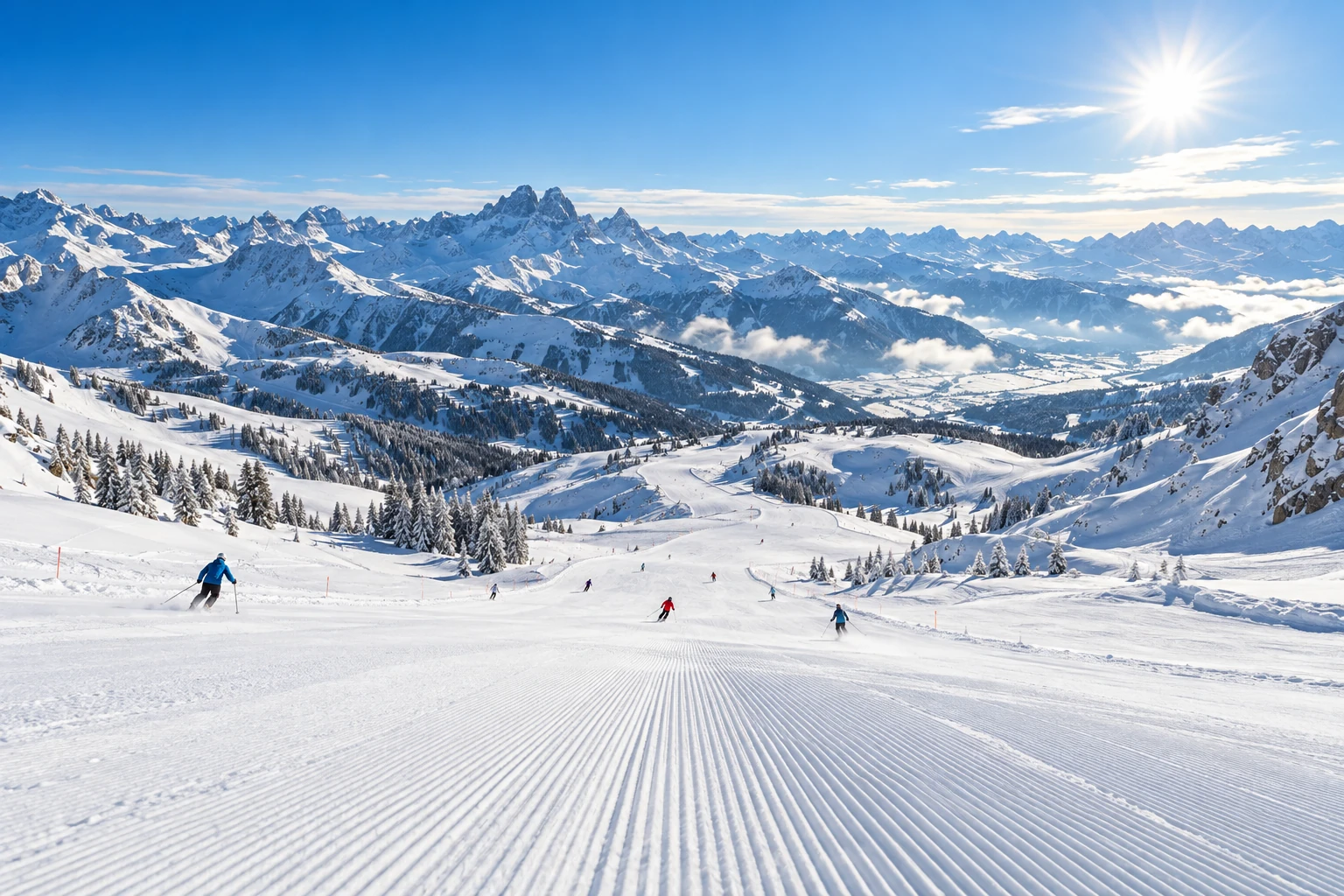 Last-Minute-Skiurlaub Präparierte Piste mit Skifahrern vor weitem Gipfelpanorama – Last-Minute-Skiurlaub